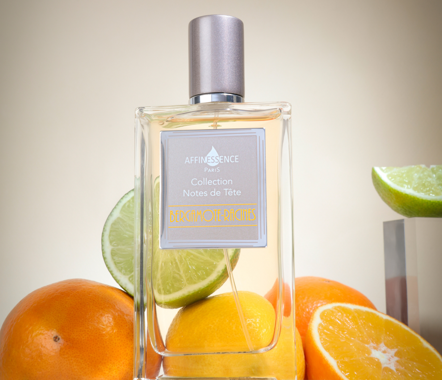 Affinessence Bergamote-Racines perfume bottle labeled 'Collection Notes de lète' with citrus fruits in the background.