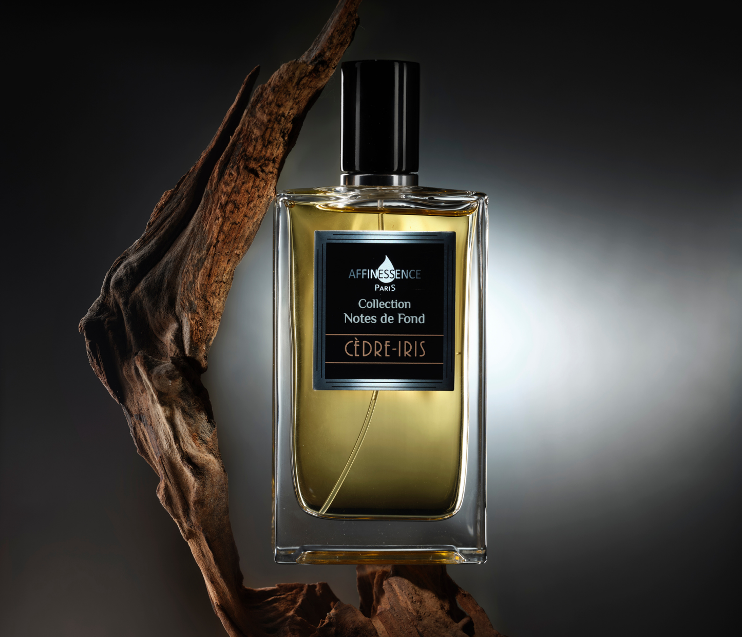 Affinessence Cedre-Iris perfume bottle displayed on a piece of wood on a dark background.
