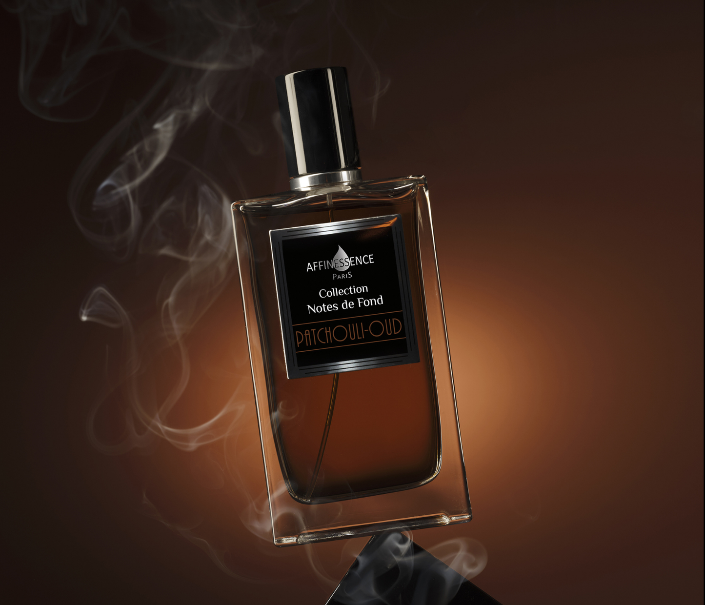 Affinessece Patchouli-Oud perfume bottle with smoke effect on a dark background.