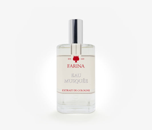 A bottle of the luxury perfume Eau Musquee by Farina 1709 set against a pale background.